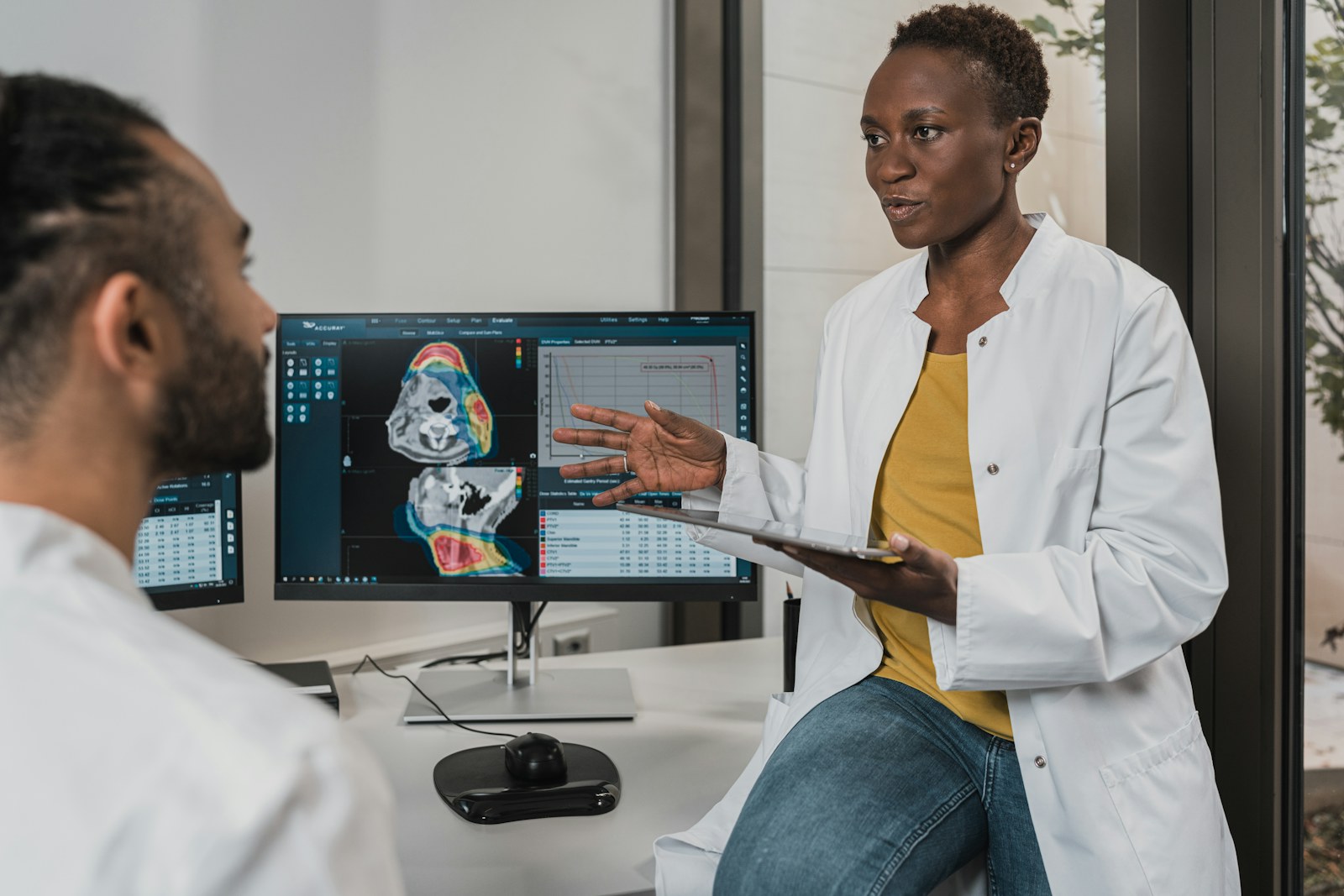 Clinicians reviewing breast imaging on a monitor